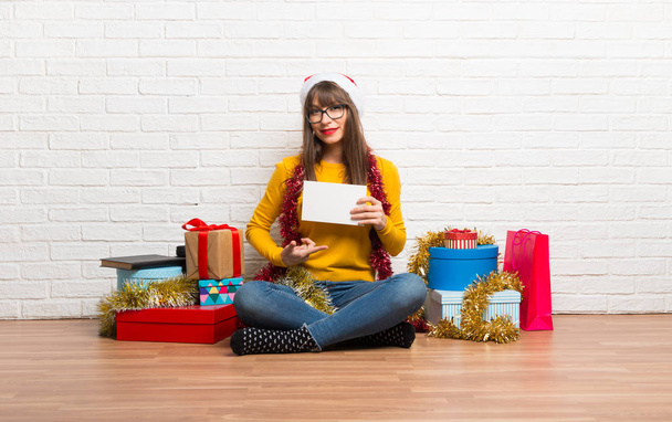 Girl celebrating the christmas holidays holding an empty white placard for insert a concept - Photo, image