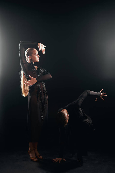 Beauty, fashion. Dancing over black background, beautiful couple of ballet dancers - Fotó, kép
