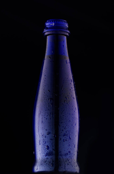 Blue beautiful bottle on a black background - Foto, afbeelding