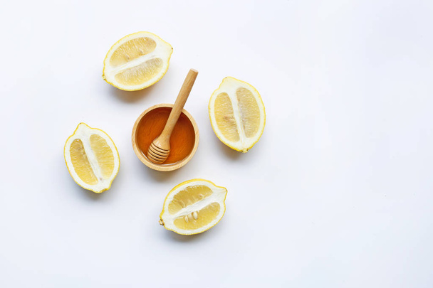 Honey with lemon on white background. Copy space - Zdjęcie, obraz