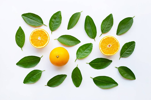 Bovenaanzicht van oranje vruchten met groene bladeren, geïsoleerd op witte achtergrond. - Foto, afbeelding
