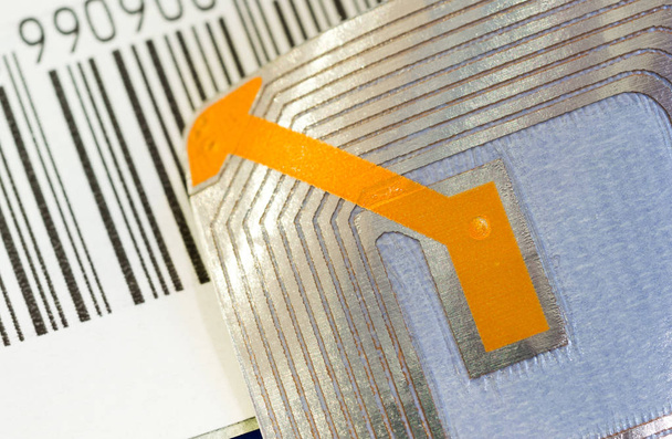 Gros plan des étiquettes RFID et d'une barre de code utilisée à des fins de suivi et d'identification et comme système antivol dans le commerce et la vente au détail
. - Photo, image