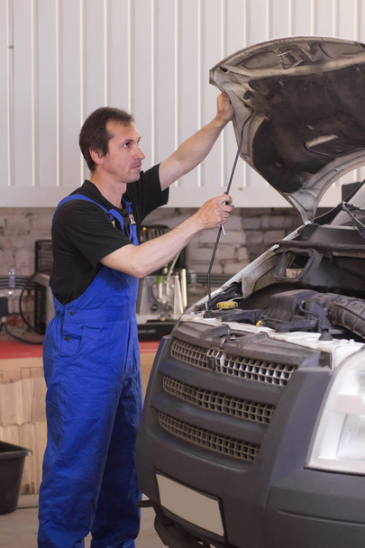 Técnico que trabaja en el servicio de automóviles y la reparación de un coche
 - Foto, imagen