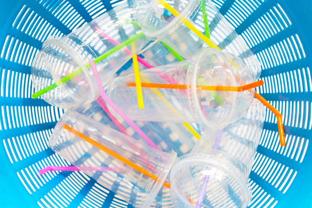 Vasos de plástico con paja en la cesta de residuos
. - Foto, imagen