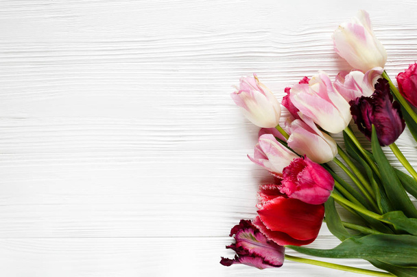Barevné krásné tulipány na bílý dřevěný stůl. Valentýna, jaro pozadí. květinové mock-up s copyspace. šťastné matky den, romantické zátiší, čerstvé květiny - Fotografie, Obrázek