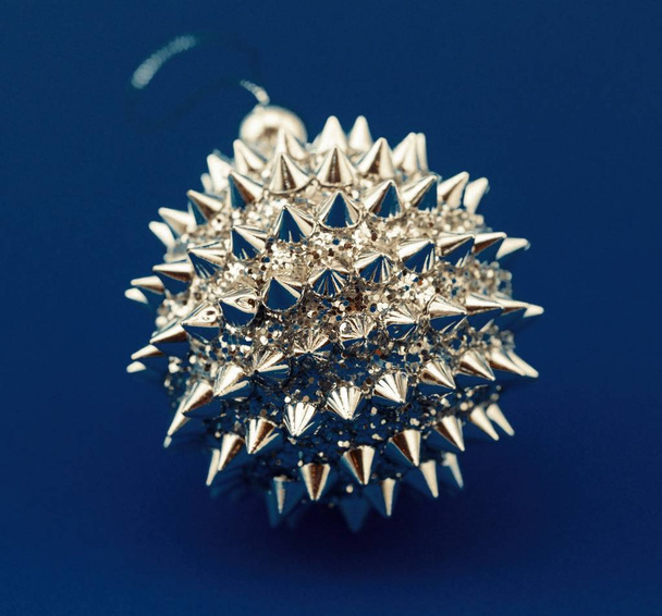 Christmas silver ball with spikes on blue background. Christmas decorations - Photo, Image