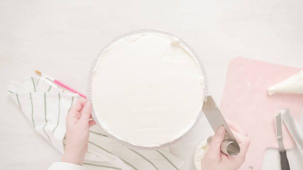 Flat lay. Frosting pink and purple cake with a white buttercream icing. - Foto, afbeelding