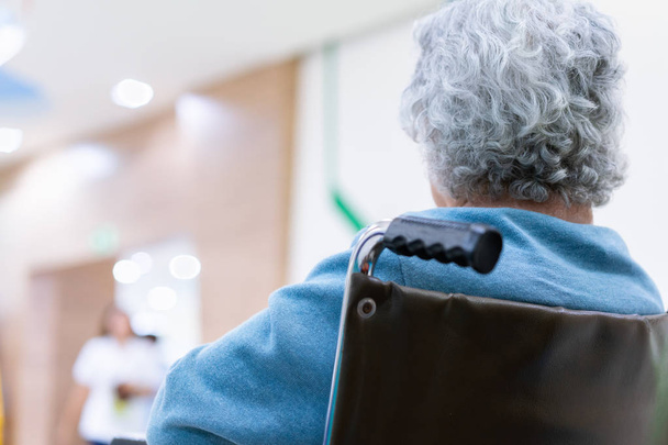Vanhempi potilas nainen pyörätuolissa odottamassa lääkäriä sairaalassa
 - Valokuva, kuva