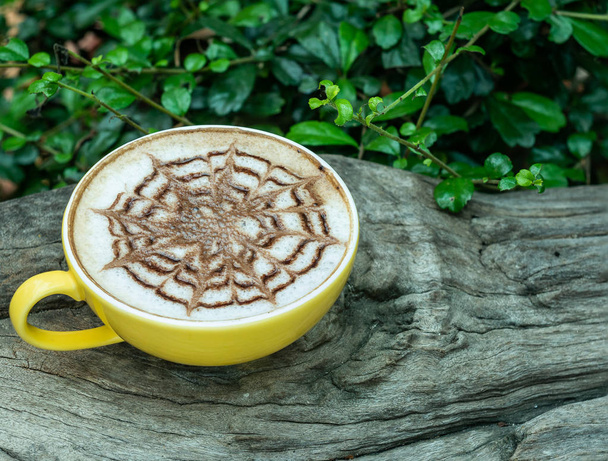 Filiżankę kawy latte napój na drewnianych z tło zielony liść. - Zdjęcie, obraz