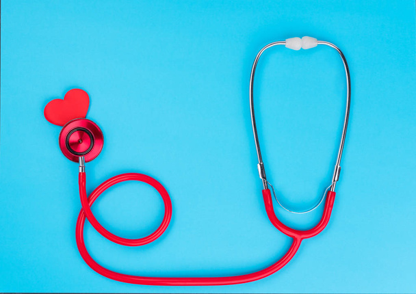 Red stethoscope or phonendoscope  on blue table background with copy space for  text. Medicine concept - Photo, Image