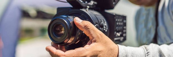 a professional cameraman prepares a camera and a tripod before shooting BANNER, long format - Фото, зображення