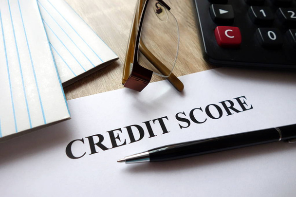 Credit score document with pen, calculator and glasses on desk - Photo, Image