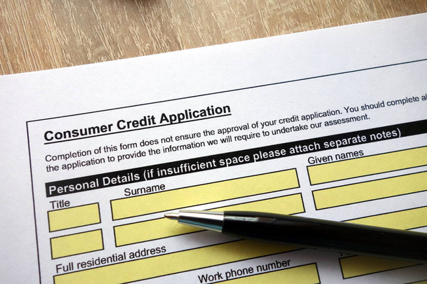 Formulário de pedido de crédito ao consumidor com caneta na mesa
 - Foto, Imagem