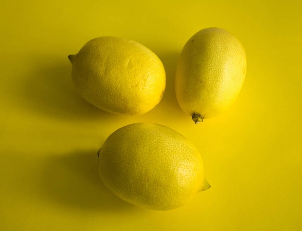 Limoni gialli maturi isolati su fondo giallo
 - Foto, immagini