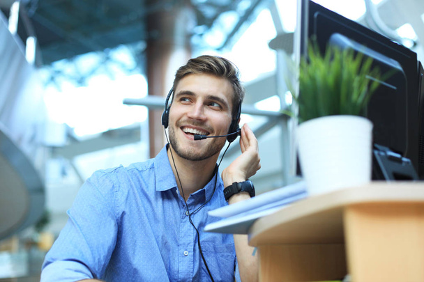 Smiling friendly handsome young male call centre operator. - Foto, Imagen