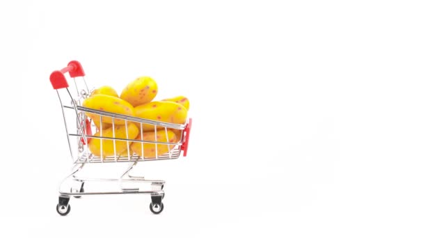 Half frame. Supermarket trolley. Shopping cart with yellow ulluco tubers. Rotating. Isolated on the white background. Close-up. Macro. - Filmati, video