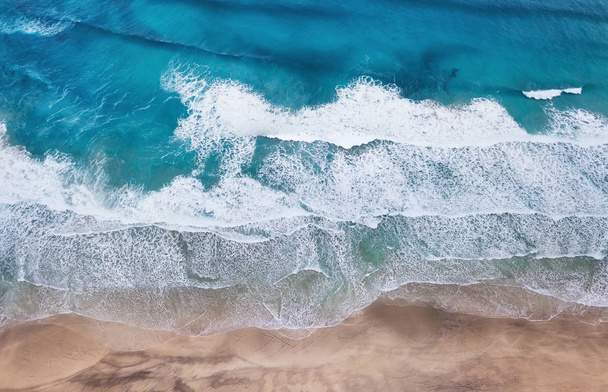 Pláž a vlny z horního pohledu. Tyrkysové vodní pozadí z horního pohledu. Letní mořská pláň ze vzduchu. Pohled shora z dronu. Cestovní koncept a nápad - Fotografie, Obrázek
