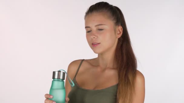 Preciosa mujer disfrutando del agua potable de una botella, aislada
 - Metraje, vídeo