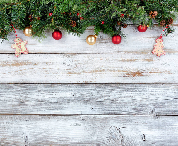 Επάνω περίγραμμα του Χριστούγεννα αειθαλή κλαδιά με άλλες διακοσμήσεις διακοπών, στο λευκό ρουστίκ ξύλο - Φωτογραφία, εικόνα