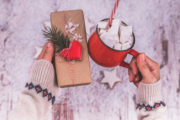 Mãos de mulher segurando uma caixa de presente de Natal e
 - Foto, Imagem