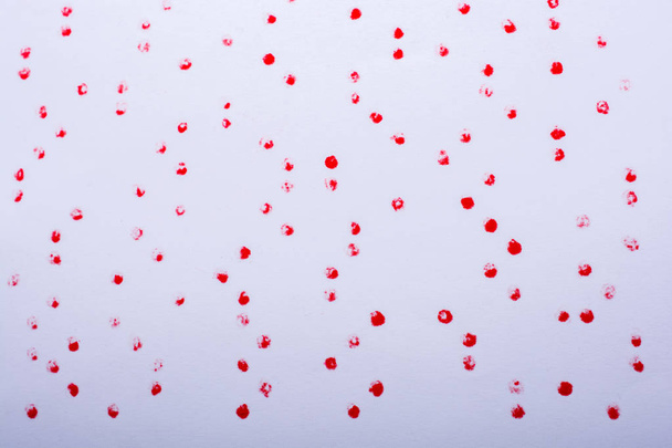 Red paint dots on a white background on display - Fotoğraf, Görsel