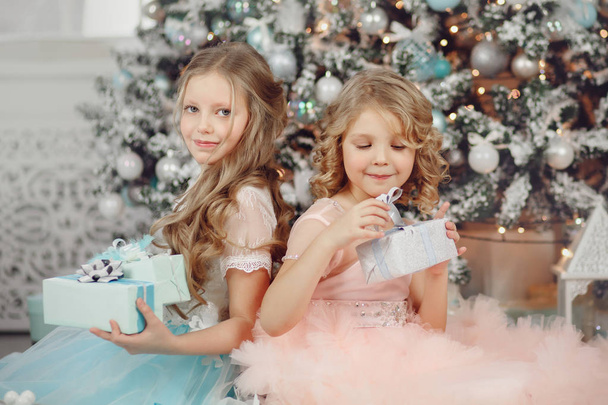 Щасливі діти сестри відкривають магічний подарунковий будинок біля дерева в одязі. Веселого Різдва
. - Фото, зображення