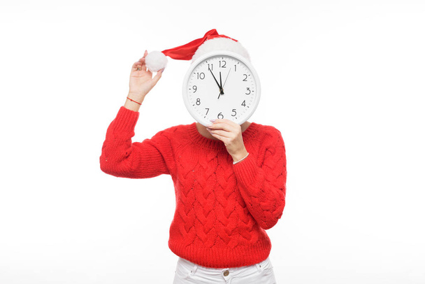 Late new year and christmas shopping girl with big wall clock in santa claus hat on isolatad white background - Foto, afbeelding