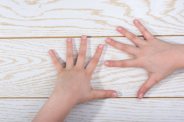 Handen maken van een gebaar op een houten achtergrond - Foto, afbeelding