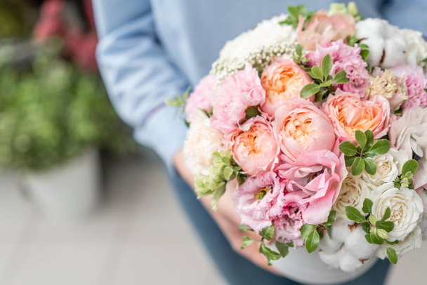 floral bunch in head box. European floral shop. Bouquet of beautiful Mixed flowers in woman hand. Excellent garden flowers in the arrangement , the work of a professional florist. - 写真・画像