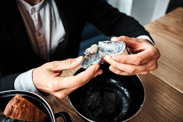 красивый молодой бизнесмен ест морепродукты в роскошном ресторане
 - Фото, изображение