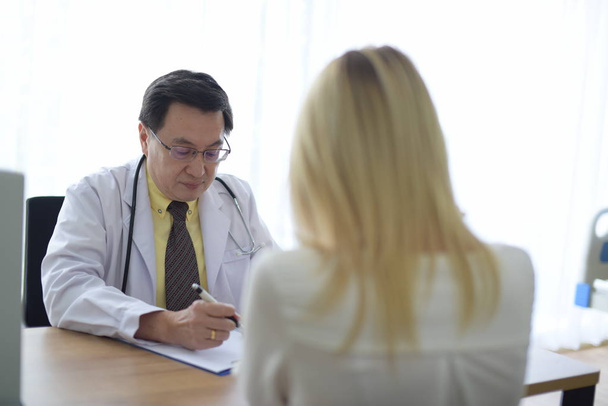 Ärztin spricht mit Patientin am Tisch - Foto, Bild