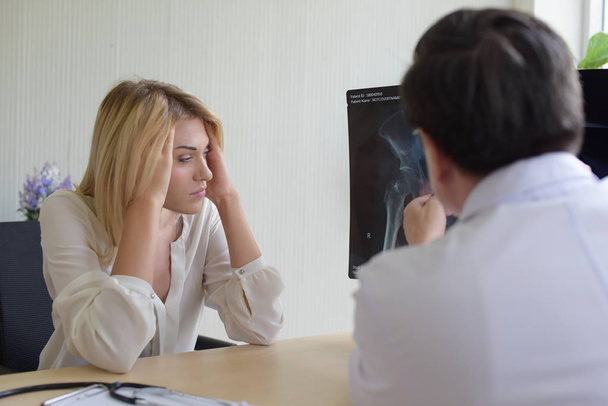 病院で医師の精神科医と話している女性は問題を話し合うし、精神的な健康上の問題に解決策を見つけます。必死と強調した頭痛に苦しむ若い美しい女性. - 写真・画像