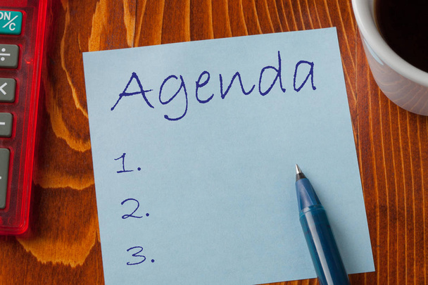 Agenda written on note with pen a side, cup of coffee and calculator. Business Concept. - Photo, Image