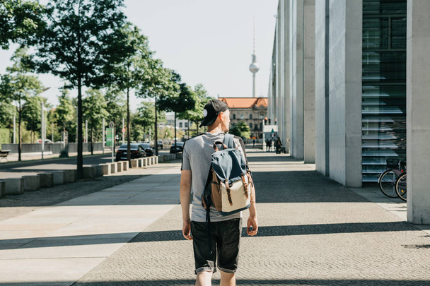 Ένας τουρίστας με ένα σακίδιο που περπατά κατά μήκος ενός δρόμου στο Βερολίνο. - Φωτογραφία, εικόνα