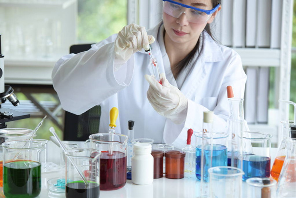 Jovens cientistas estão experimentando ciência no lab. cientista asiático segurando um tubo de ensaio em um laboratório
 - Foto, Imagem