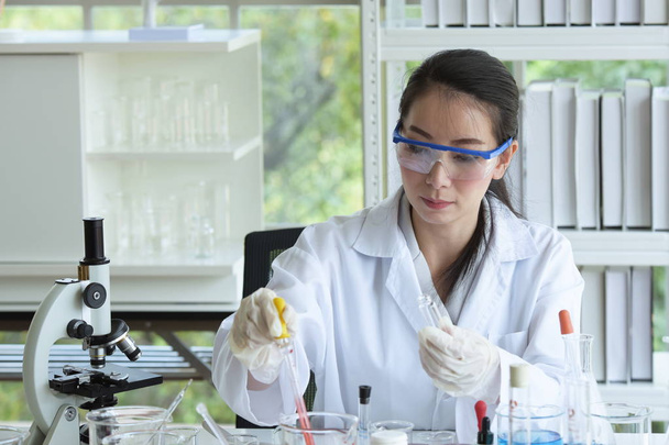 Asian female scientist working in laboratory - Фото, зображення