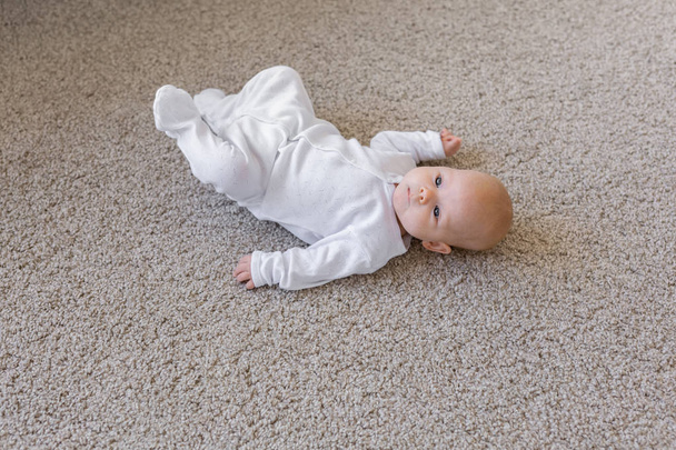 Concept d'enfance, de nourrisson et de personne - petit bébé couché sur le sol
 - Photo, image