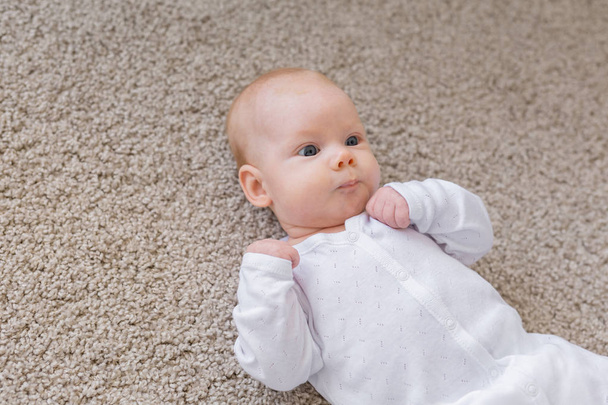 Baby, infant and childhood concept - Top view of the child on the floor - Photo, Image