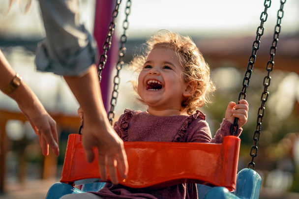Adorable little girl having fun on a swing - Fotografie, Obrázek