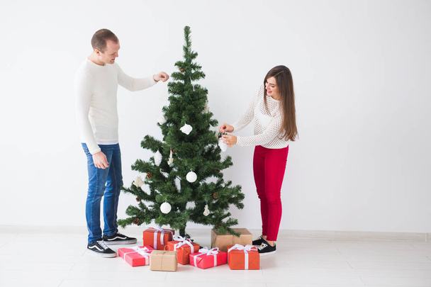 Zimní svátky koncept - šťastné lásky pár zdobení vánočního stromku v místnosti - Fotografie, Obrázek