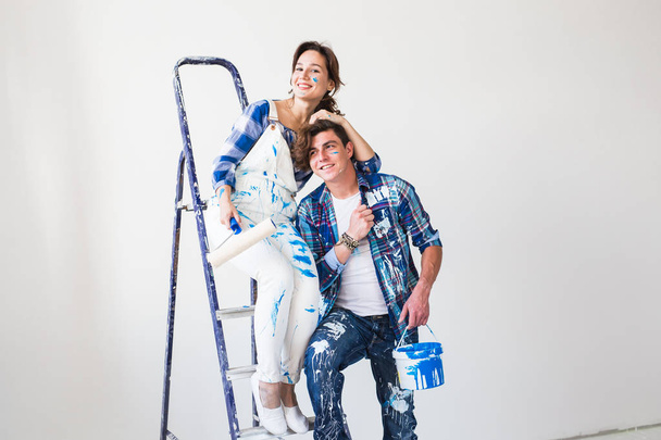 Люди, концепція ремонту та стосунків - молода смішна пара робить ремонт у новій квартирі
 - Фото, зображення