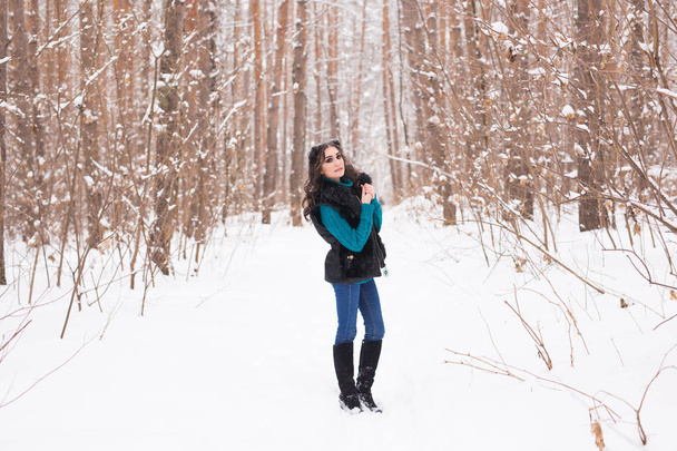 Inverno, temporada e conceito de pessoas - Jovem mulher bonita andando no parque nevado
 - Foto, Imagem