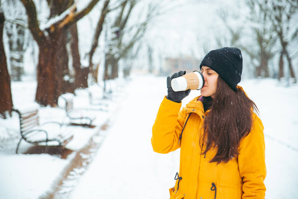 picie kawy poza w park portret kobiety. napoje. czas zimowy. ogrzać się koncepcja - Zdjęcie, obraz