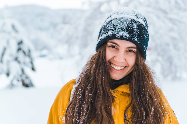 donna sorridente ritratto all'aperto neve sul cappello stagione invernale
 - Foto, immagini