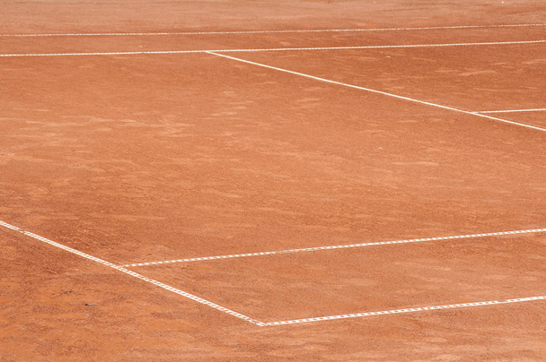 Parte da superfície de campo de ténis de barro vermelho usado vazio com linhas brancas close-up
 - Foto, Imagem