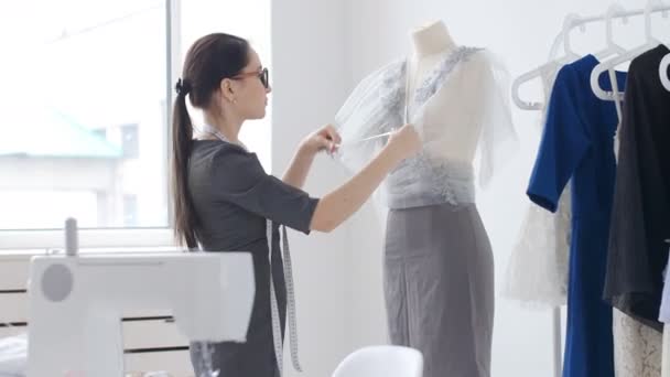 Concepto de diseño y producción de ropa. Joven diseñador de ropa costurera trabajando en su estudio
 - Metraje, vídeo