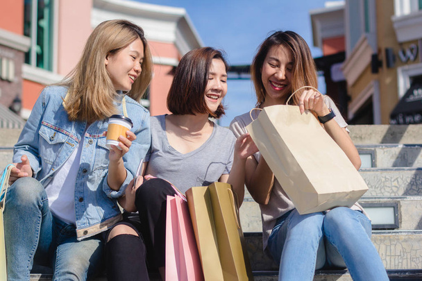 Genç Asyalı kadın ellerinde alışveriş torbaları ile açık bir pazarda alışveriş grubudur. Genç Asyalı kadınlar sıcak güneş ışığı altında alışveriş torbasında marifetlerini göster. Grup açık alışveriş kavramı. - Fotoğraf, Görsel