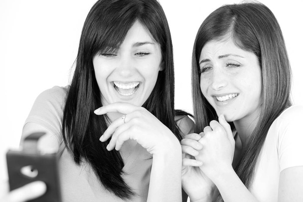 mujeres jóvenes lindas divirtiéndose con teléfono inteligente
 - Foto, Imagen