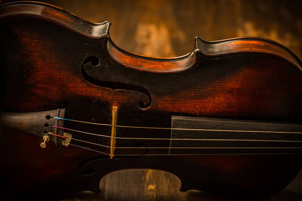 Деталь старої скрипки в старовинному стилі на фоні дерева
 - Фото, зображення