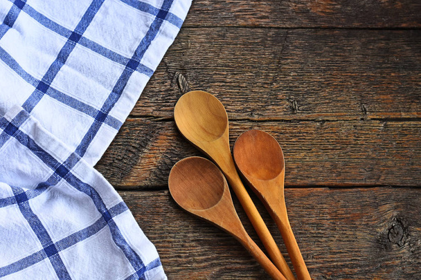 Une image de cuillères à mélanger en bois et nappe colorée sur un dessus de table de cuisine de campagne de style ancien
.  - Photo, image